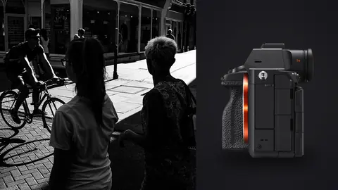 Sony a7R V product photo beside two women walking past a cyclist on a shopping street