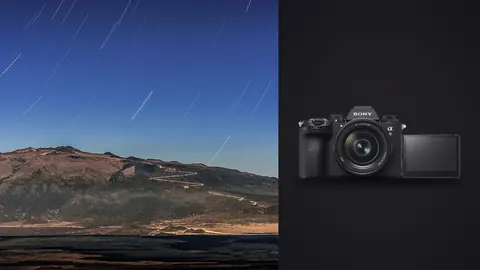 Sony a9 III product photo beside faint star trails above a dark volcanic mountain ridge