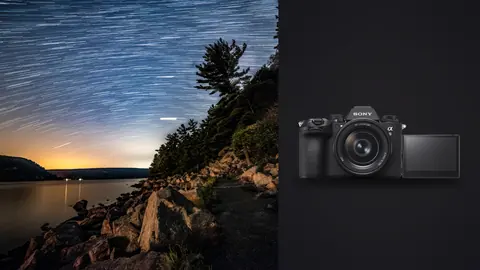 Sony a9 III product photo beside star trails above a rocky shoreline path with trees