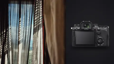 Sony a9 III product photo beside dark curtain with diagonal light bars, moody