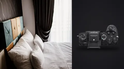 Sony a9 III product photo beside bed with plush white pillows lit by sheer curtains in daylight