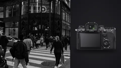 Sony a9 III product photo beside crowd of pedestrians crossing a street by a glass storefront