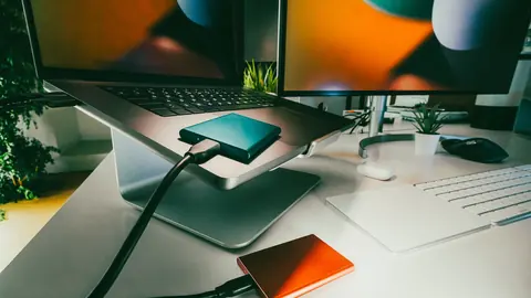 Two portable external drives connected to a laptop on a desk