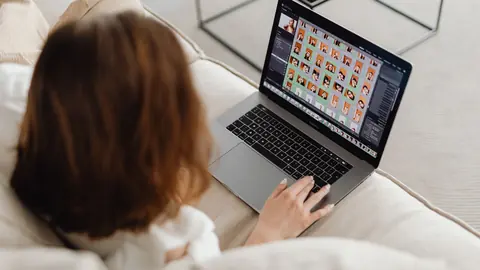 Person viewing a grid of portrait photos on a laptop screen