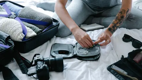 Camera and packing organizers laid out beside an open suitcase