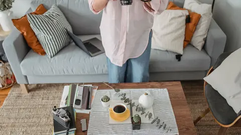 Photographer actively shooting a styled living room interior with a camera