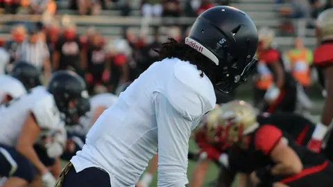 Football player set at the line of scrimmage during a live game
